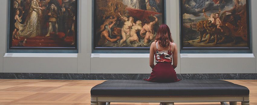 femme regardant tableaux dans musées - accessibilité aux PMR