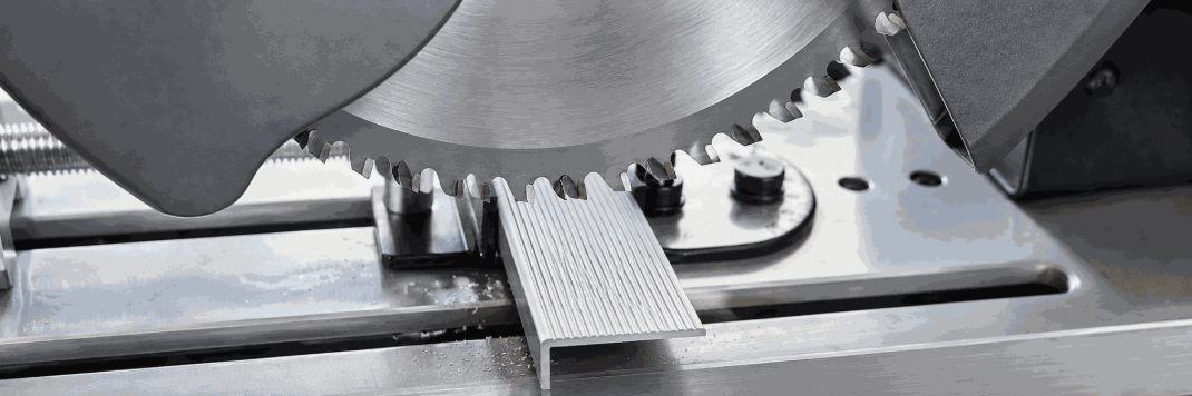 Découpe d'un nez de marche strié en aluminium à la scie, dans l'atelier Handinorme